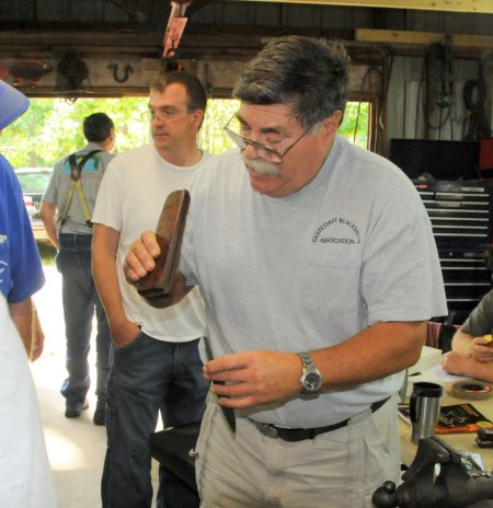 Using a slotted wooden drift to set the silver guard on the tang